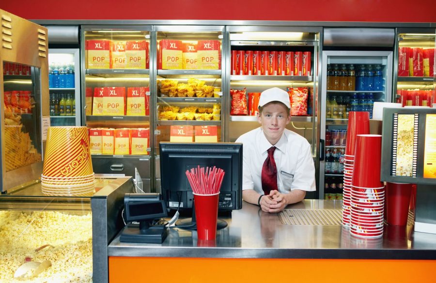 A visual example of a teenage boy working at a movie theater food counter.  