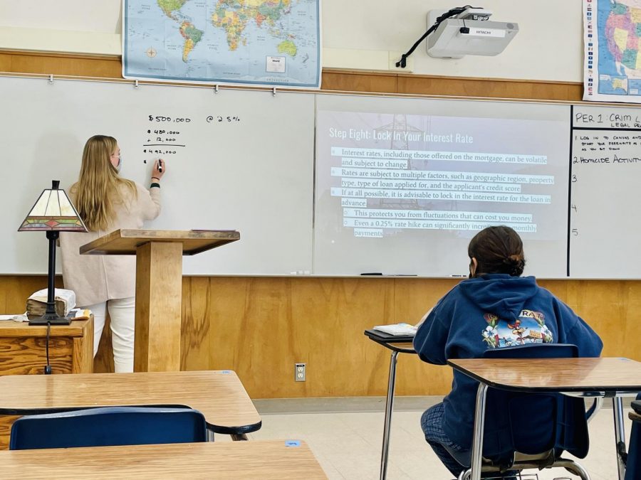 INTERESTING. Lauren Rad teaches her second period CTE Civil Law, about interest rates, explaining it more thoroughly to her students on the whiteboard, next to the information on the slide. “I wish I had known this before buying a house.” Rad said. “This is a long process, there is a lot that goes into this.”
