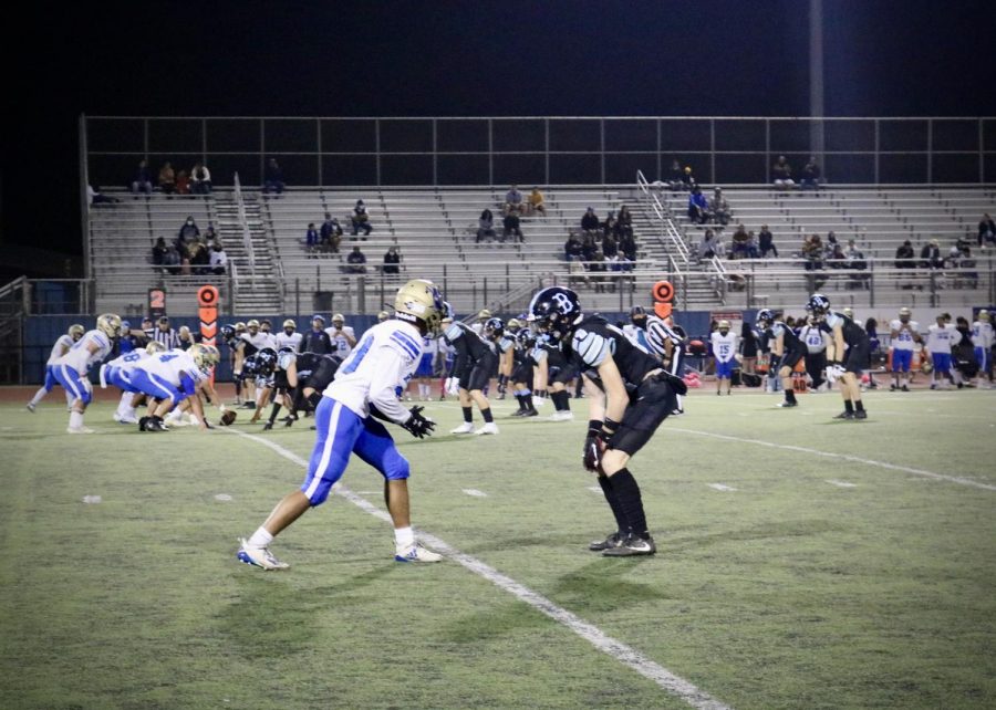 With the crowd cheering Junior Ty Morris takes the field to guard Channel Islands wide receiver before the snap.
