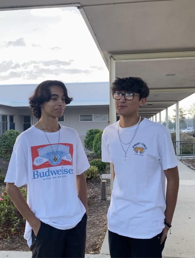 Two buena students,  show the shirts they got dress coded in.