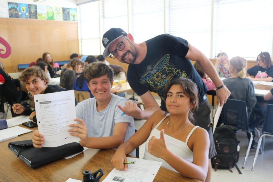 Jason Greenberg is walking around at the end of class checking the homework assignments from freshmen Math 1 Honor students Alyssa Angeles, Dylan Perez, Chase Strople (right to left). “Always do your homework :),” Greenberg said.
