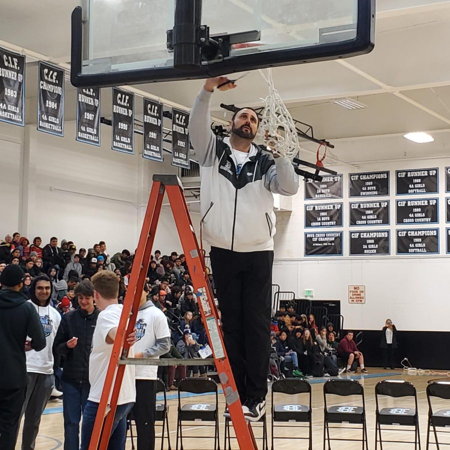 Coach Matthew Colton makes final cuts to the net and season during ceremony