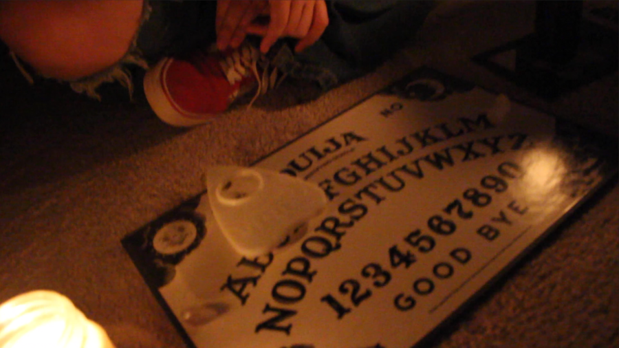 A screenshot for "Thompson Manor Terror," where Margaret Thompson, Jacqui Meijer, and Audrey Espinosa use a Ouija board.