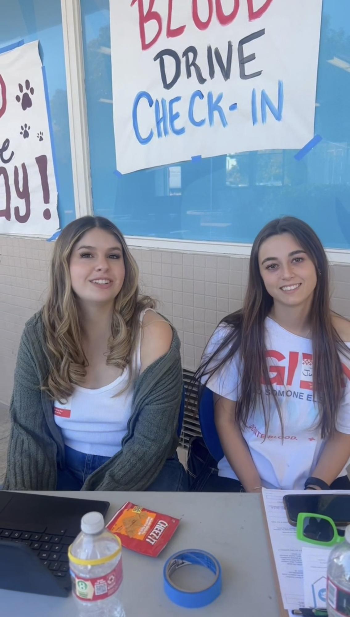 Savanna Countryman (left) and Juliet Lichtman (right) greet students at the blood drive. 