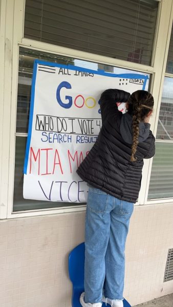 Mia Martinez putting up her poster to get students votes