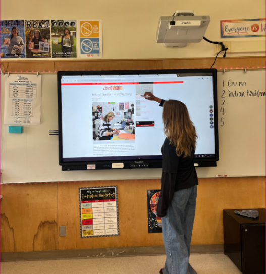 Sophomore Avery Buehner researches an article on the Promethean Board. Ever since it was added to her classroom, it has brought numerous issues.