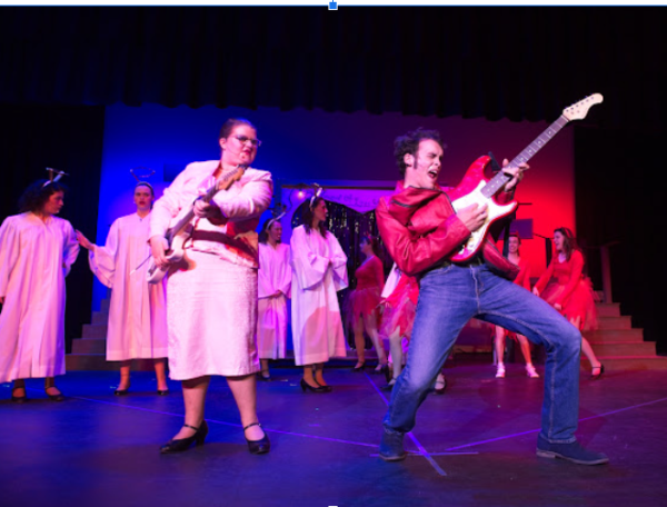 Freshman Lily Beck (left) and senior Adam Karluk (right) rock out to some Elvis tunes after the mayor, played by Beck, let loose on the towns strict rules and played to her hearts desire. 
