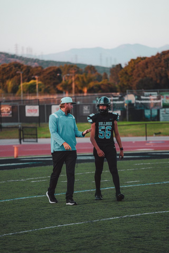 Adam Colman talking to JV football player Andrew Bishop during the San Marcos - Buena Game