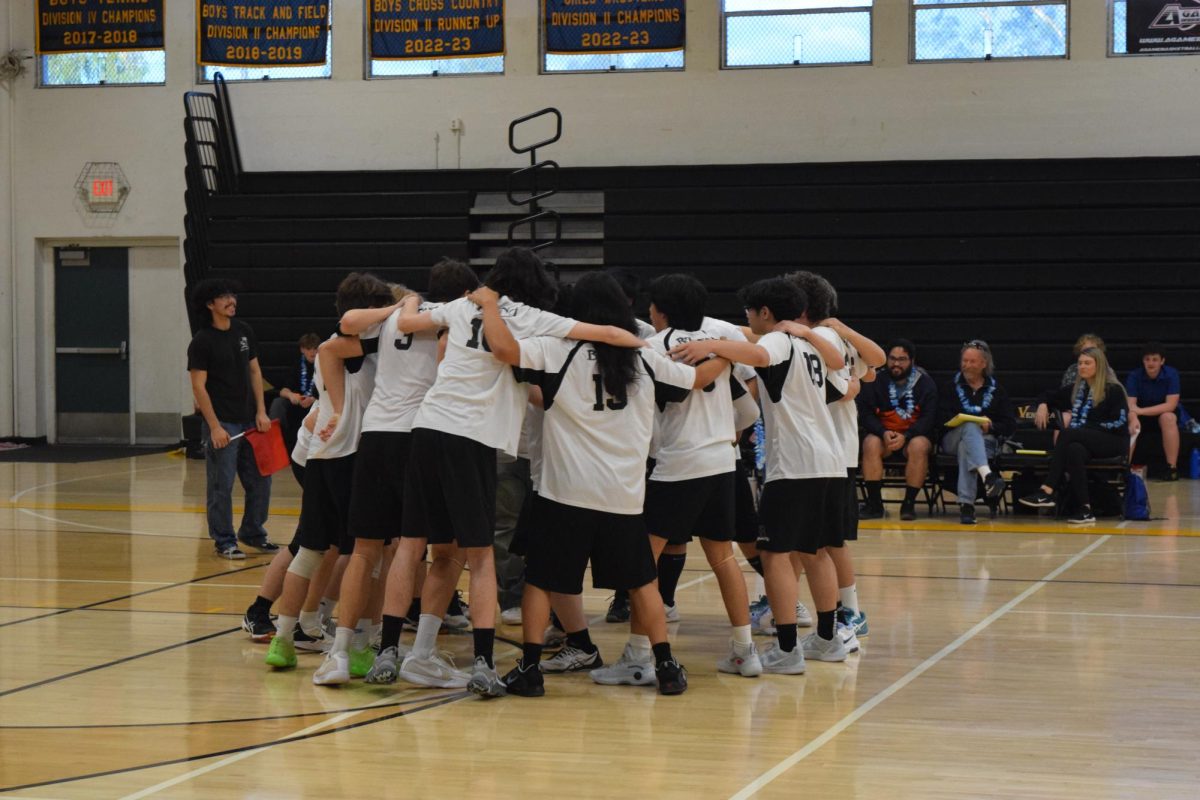 The Bulldogs charge up in their huddle as they prepare to take on their cross-town rivals.