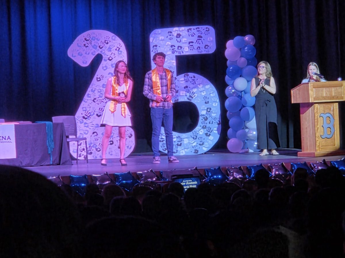 Valedictorian Graham Strople and salutatorian Danika Jones stand on the stage together as they receive their awards.