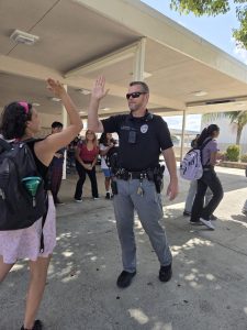 Officer Thompson high-fives passing students during lunch
