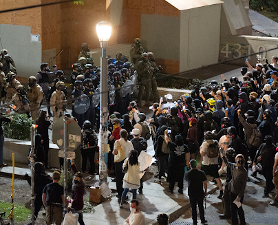 Portland protesters separated by a fence from the federal agents.