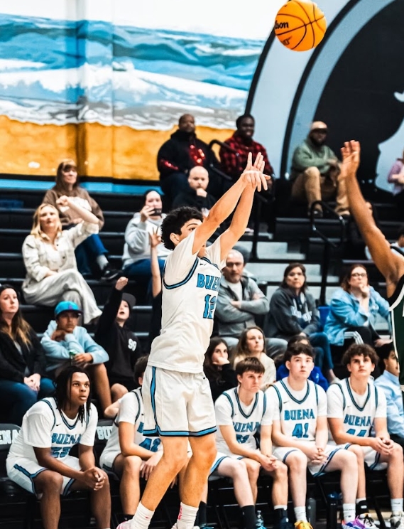 Senior Aron Rodriguez shoots a three-pointer as the crowd waits on the edge of their seat.