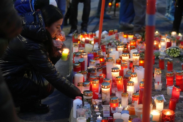 Swiss locals light candles in remembrance of the lives lost during the Swiss fire. 