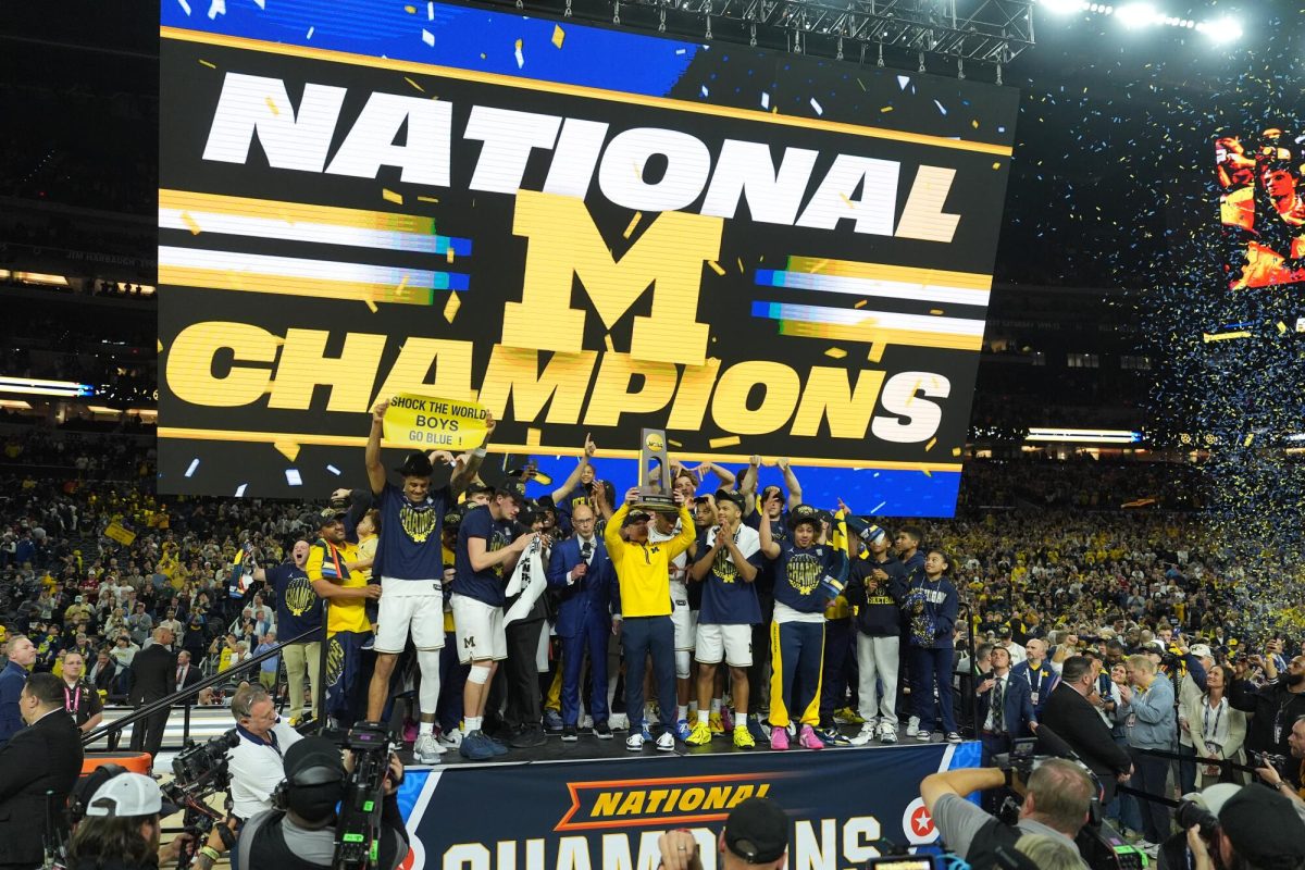 Michigan Wolverines celebrating their win and getting their trophy.